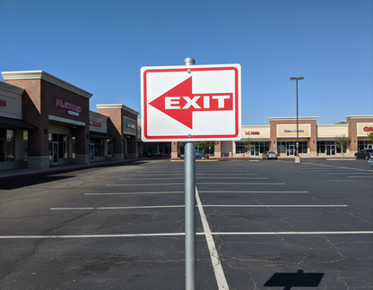 Exit sign in a parking lot with a clear blue sky